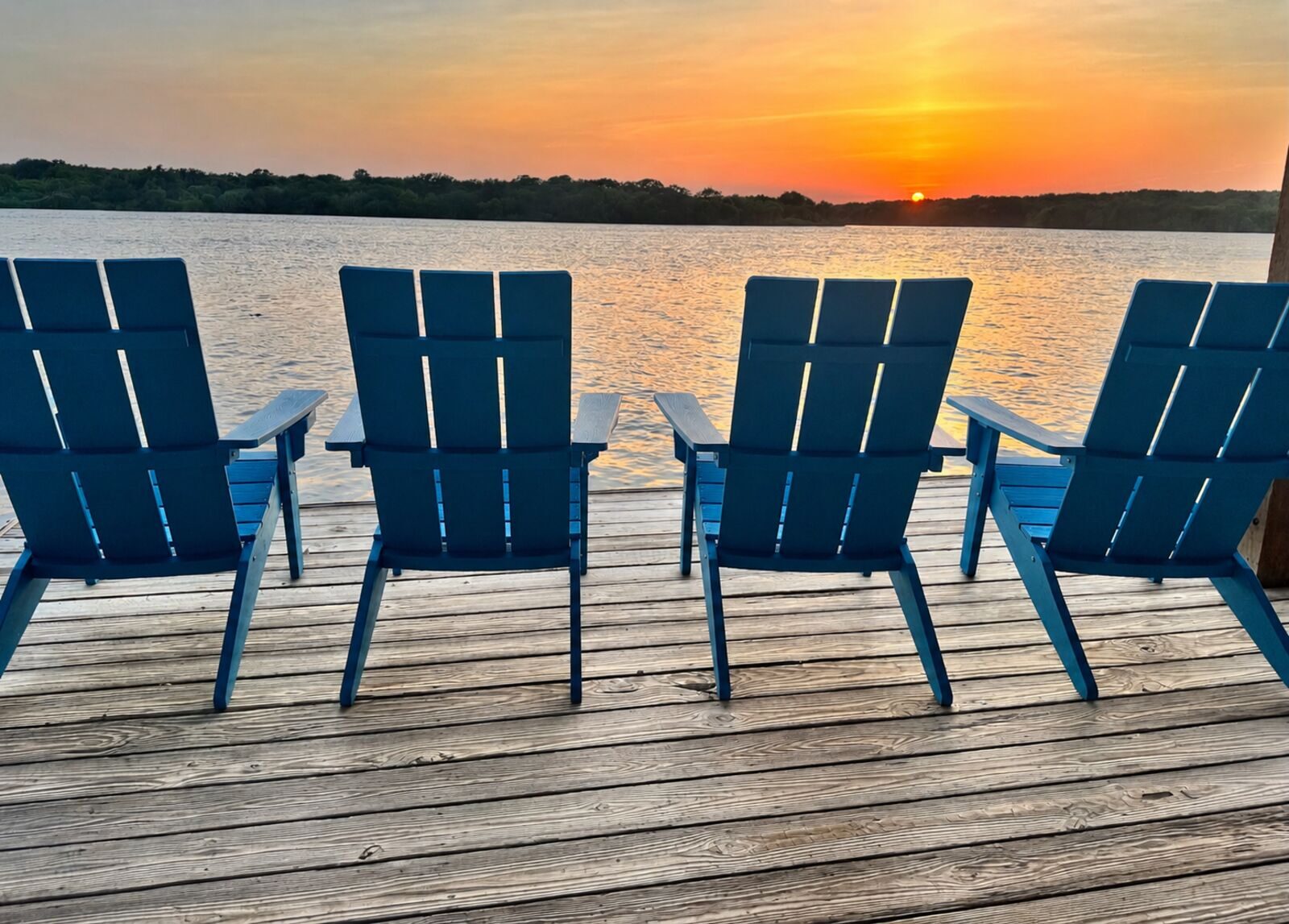Sunset from the dock with Adirondack chairs